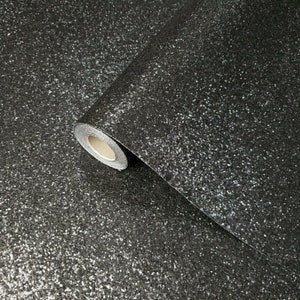 May include: A roll of black glitter wallpaper with a silver sparkle finish.