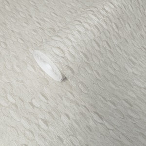 May include: A roll of beige wallpaper with a textured, embossed pattern that resembles small, wavy lines.