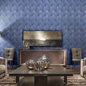 May include: A living room interior with a blue diamond patterned wallpaper, a dark wood cabinet with a television above it, two chairs, and a coffee table with three silver decorative spheres.