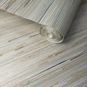 May include: A roll of natural woven wallpaper with a light brown and white striped pattern. The wallpaper is rolled up and the end of the roll is visible.