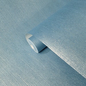 Puede incluir: Un rollo de papel tapiz azul texturizado con un brillo sutil. El papel tapiz tiene un patr&oacute;n acanalado y est&aacute; enrollado.