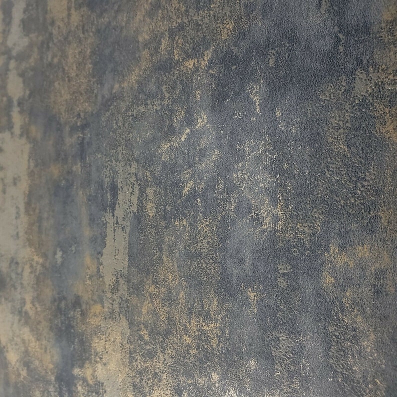 May include: A textured background with a dark gray base and a light gold overlay. The surface has a rough, uneven texture.