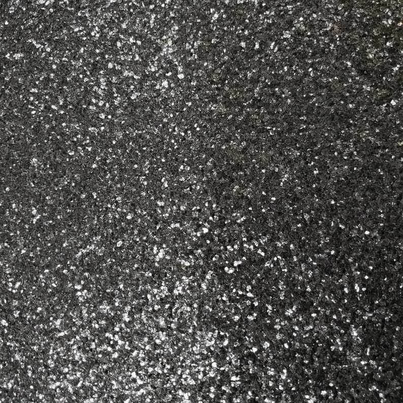 May include: A close-up of a black sparkly surface with a fine-grained texture.