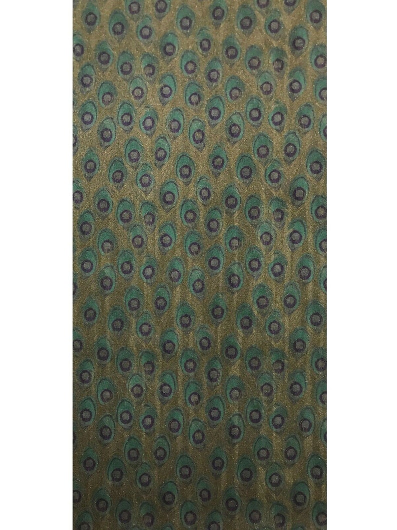 May include: A green and gold fabric with a repeating pattern of peacock feathers.