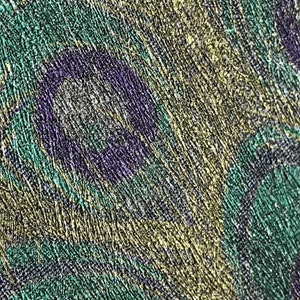 May include: Close-up of a textured fabric with a pattern of overlapping circles in shades of green, purple, and gold.