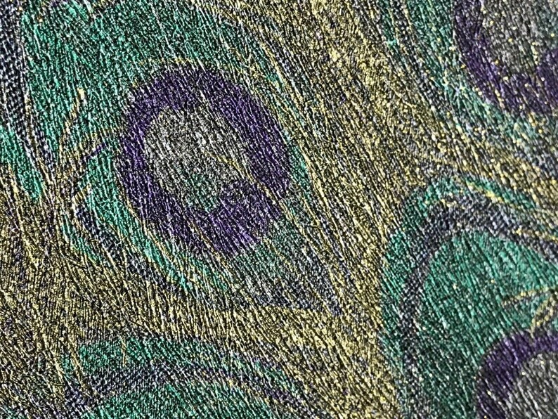 May include: Close-up of a textured fabric with a pattern of overlapping circles in shades of green, purple, and gold.