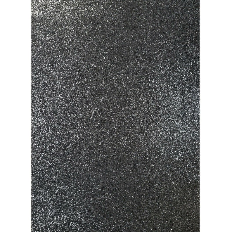 May include: Black textured background with a fine white glitter finish.