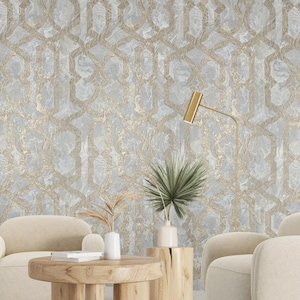 May include: A living room interior with two beige armchairs, a wooden coffee table, and a potted plant. The wall is covered in a light blue and gold geometric wallpaper with a marble effect.