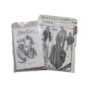 May include: Two vintage sewing pattern packets. One packet is labeled "Great Copy Pattern" and features illustrations of ponchos. The other packet is labeled "Stretch & Sew" and features illustrations of ponchos and cocoons. Both packets are in plastic.