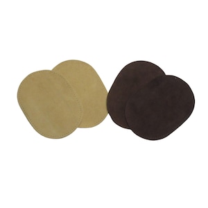 May include: Four oval-shaped leather patches. Two are a light tan color, and two are a dark brown. The patches are arranged in two pairs, each pair slightly overlapping. The edges of the tan patches have a visible stitch.