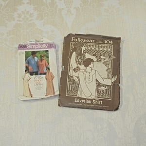 May include: Two vintage sewing pattern packets. One is a Simplicity pattern with a photo of people wearing the finished garments. The other is a Folkwear pattern for an Egyptian Shirt.