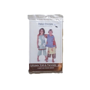 May include: A sewing pattern package titled Uptown Tops & Trousers by Indygo Junction. The cover features two children wearing sleeveless tops and cropped trousers with various patterns and colors, including light blue, purple, and brown tones.