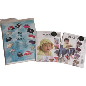 May include: Three vintage sewing pattern booklets. One is a blue and white bag with hat illustrations and the text "The Hat Shoppe." The other two are McCall's Fashion Accessories and McCall's Crafts patterns.