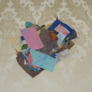 May include: A pile of colorful fabric scraps in various patterns and textures, including pink, blue, green, and brown.