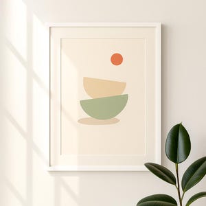 Könnte beinhalten: Gerahmter abstrakter Kunstdruck mit minimalistischem Design. Das Kunstwerk zeigt zwei gestapelte, halbkreisförmige Formen in gedämpftem Grün und Beige, mit einem kleinen orangefarbenen Kreis darüber. Der Druck ist vor einem cremefarbenen Hintergrund.