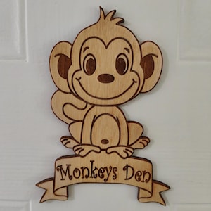 May include: Wooden cutout of a smiling monkey with a banner that reads "Monkeys Den".