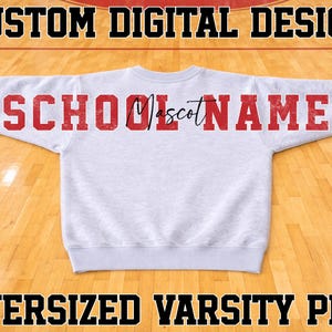 May include: A light gray long-sleeve sweatshirt featuring the red text SCHOOL MASCOT NAME across the back. The word SCHOOL is in a block font, the word Mascot is in a black script font, and the word NAME is in a red block font.