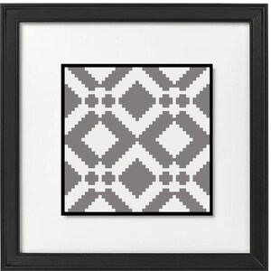 May include: A framed print featuring a geometric pattern in gray and white. The artwork is a repeating design of diamond shapes and smaller square elements. The print is set within a white mat and a black frame.