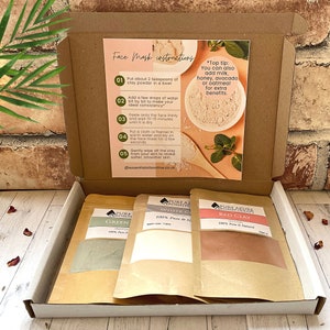 May include: A box containing three small bags of clay powder for face masks. The bags are labelled "Green Clay", "White Clay", and "Red Clay". The box also includes instructions for using the clay powder.