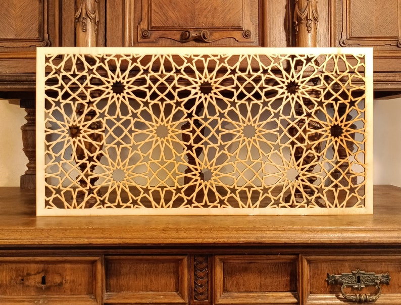 May include: A wooden decorative screen with a geometric pattern of stars and circles. The screen is made of light wood and has a natural finish.