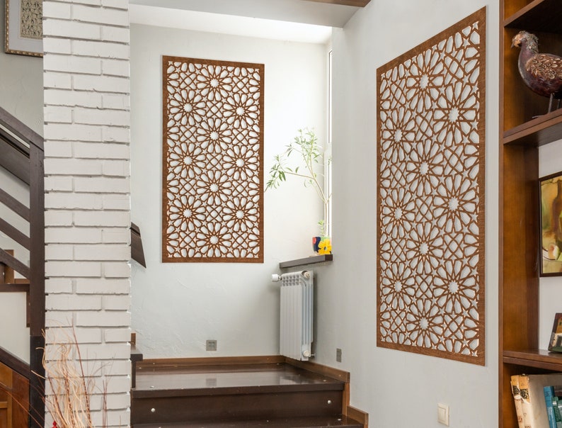 May include: Two brown wooden wall decor panels with intricate geometric patterns, hanging on white walls in a modern home.