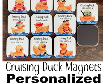 May include: Nine white square magnets with a cartoon image of a rubber duck in a variety of poses. Each magnet has the text "Cruising Duck from Tucson, Az". The magnets are on a wooden surface.