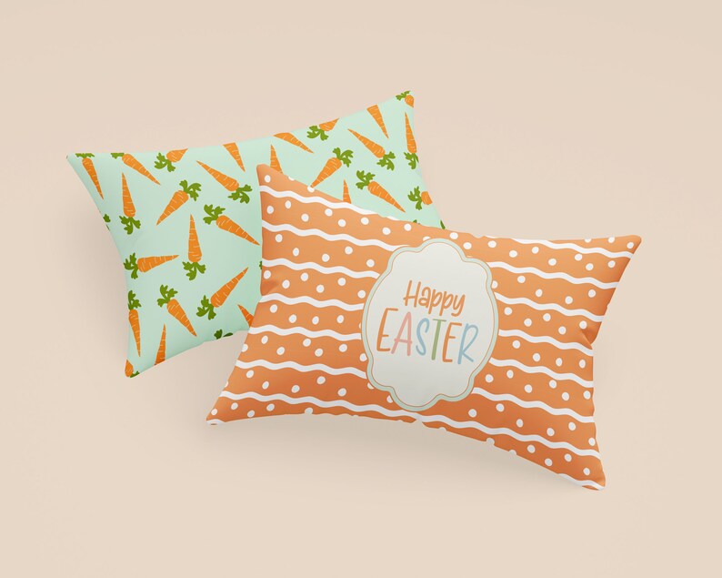 K&ouml;nnte beinhalten: Zwei dekorative Kissen mit Ostern-Motiven. Ein Kissen hat einen hellblauen Hintergrund mit orangenen Karotten, das andere Kissen einen orangenen Hintergrund mit wei&szlig;en Punkten und Wellenlinien. Das zweite Kissen hat ein wei&szlig;es Etikett mit dem Text "Frohe Ostern" in bunten Buchstaben.