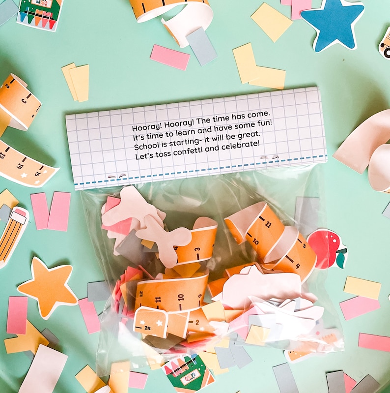 Pode incluir: Um saco de pl&aacute;stico transparente cheio de confeti colorido para uma celebra&ccedil;&atilde;o de volta &agrave;s aulas. O confeti inclui recortes de r&eacute;guas, ma&ccedil;&atilde;s, estrelas e &ocirc;nibus escolares. O saco tem uma etiqueta branca com o texto "Hooray! Hooray! The time has come. It's time to learn and have some fun! School is starting - it will be great. Let's toss confetti and celebrate!"