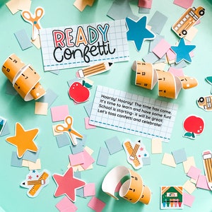 May include: A colorful confetti party kit with a sign that says "Ready Confetti!"  The kit includes a variety of confetti pieces, including stars, pencils, rulers, and school buses. The sign is on a light blue background.