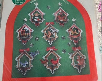 May include: A set of eight pre-cut plastic canvas shapes for crafting Christmas ornaments. The shapes are designed to be stitched with yarn and feature a variety of winter themes, including birds, houses, and reindeer. The package includes instructions for completing the designs.  Canvas Capers. Designed for your pleasure by Dick Martin.