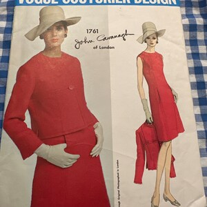 May include: A vintage Vogue Couturier Design sewing pattern featuring a red dress and jacket designed by John Cavanagh of London. The pattern number is 1761.