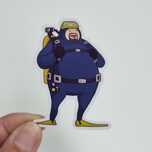 Könnte beinhalten: Eine Cartoon-Illustration eines Tauchers in einem blauen Tauchanzug, gelben Flossen und einer gelben Tauchflasche. Der Taucher hat ein breites Lächeln und hält eine Tauchermaske in der Hand.