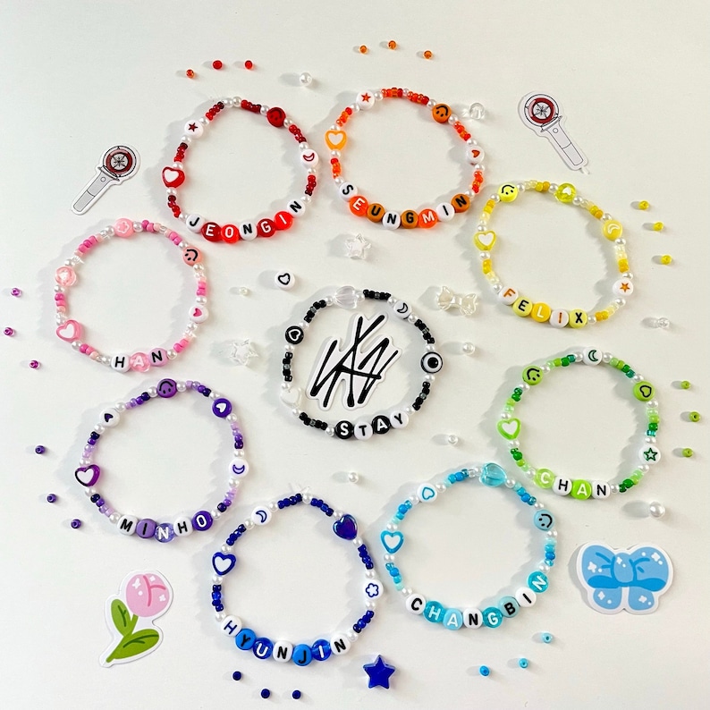 May include: Nine colorful beaded bracelets with the names of the members of the K-pop group Stray Kids spelled out on each bracelet. The names are:  Jeongin, Seungmin, Felix, Chan, Minho, Hyunjin, Changbin, and Stay.