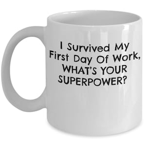 May include: White ceramic coffee mug with black text that reads "I survived my first day of work, what's your superpower?"