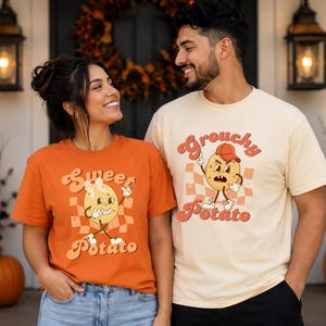 May include: An orange t-shirt featuring a cartoon potato with a bow and the text Sweet Potato, and a cream t-shirt featuring a cartoon potato with a cap and the text Grouchy Potato, both with a checkered background pattern in a retro graphic style.