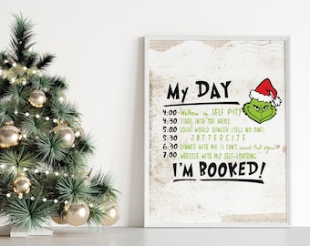 May include: A white framed print with a green Grinch character and the text "My Day" with a list of activities. The background is a distressed white wood.
