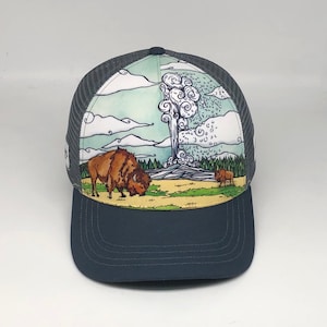 May include: A blue and white trucker hat with a graphic of a geyser erupting and a buffalo in a field. The hat has a mesh back.