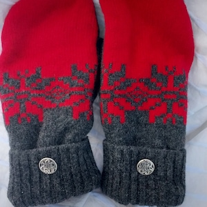 May include: A pair of red and gray knitted mittens with a decorative button on each cuff.