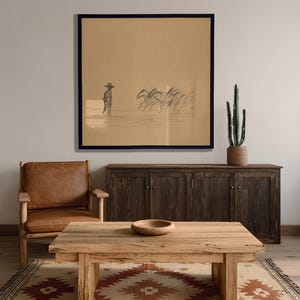 May include: A living room scene featuring a large framed sketch of a cowboy and horses. The room includes a wooden coffee table, a leather armchair, a dark wood cabinet, a patterned rug, and a potted cactus.