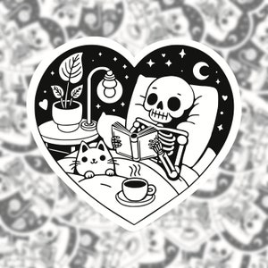 May include: Black and white illustration of a skeleton in bed reading a book with a cat and a nightlight. The skeleton is wearing pyjamas and has a cup of coffee on the bedside table.