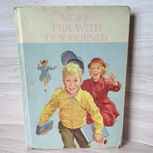 Könnte beinhalten: Ein altes Kinderbuch mit dem Titel "More Fun With Our Friends" mit blauem Hintergrund und einer Illustration von drei Kindern auf dem Cover. Die Kinder tragen bunte Kleidung und tragen Bücher.
