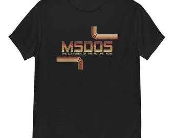 Op de afbeelding: Zwart T-shirt met de tekst "MSDOS THE COMPUTER OF THE FUTURE. NOW." in een retro lettertype met oranje en gele lijnen. Het shirt heeft een ronde hals.