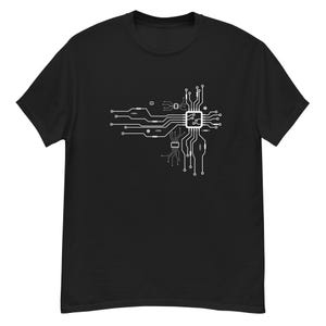 Puede incluir: Camiseta negra con un diseño de placa de circuito blanca. El gráfico es una representación detallada de las vías y componentes electrónicos, creando una estética inspirada en la tecnología. La camiseta está hecha de un material suave y cómodo.