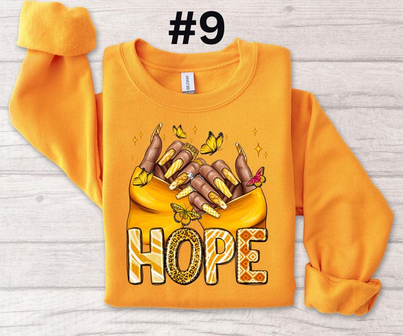 May include: Orange sweatshirt with a graphic of two hands holding each other with butterflies and the word "HOPE" in a leopard print design.