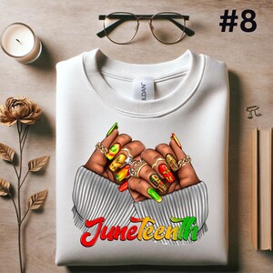 May include: White sweatshirt with a graphic of two hands with colorful nail polish and rings. The hands are clasped together and the text "Juneteenth" is printed below in red, yellow, and green.