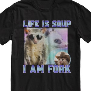 May include: Black t-shirt with a graphic of three opossums. The text "Life is Soup I Am Fork" is printed in purple on the shirt.