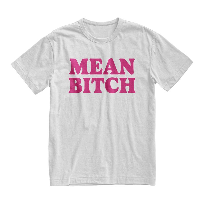 May include: White t-shirt with the words "MEAN BITCH" printed in a bold, pink font across the front. The shirt has short sleeves and a crew neck.