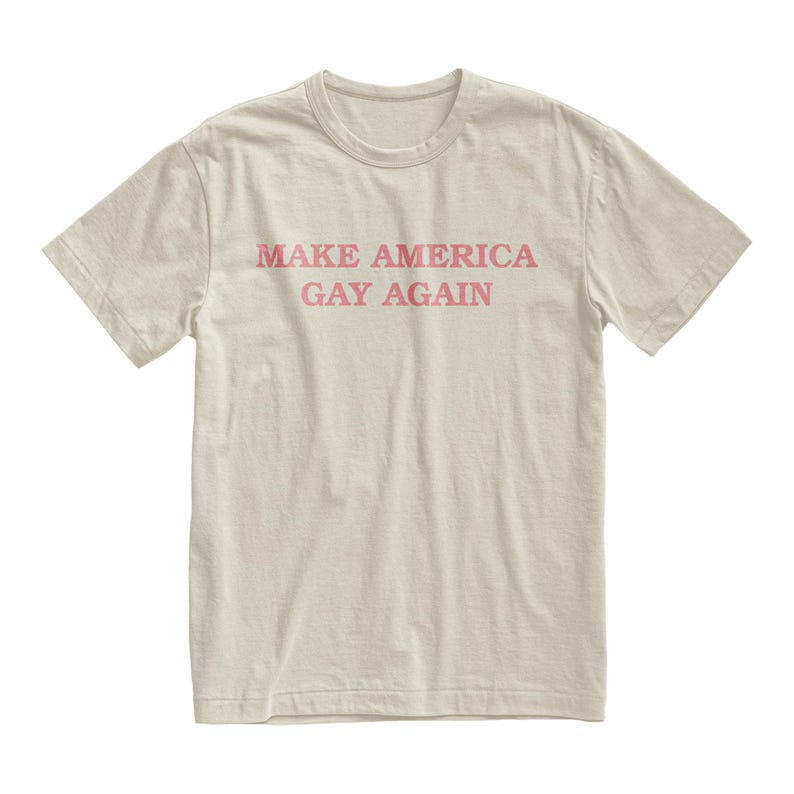 Peut inclure: Un t-shirt beige clair avec le texte "MAKE AMERICA GAY AGAIN" imprim&eacute; en rose.