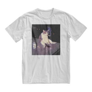Op de afbeelding: Wit t-shirt met een meme-achtige afbeelding van een kat die een sigaret rookt. De kat wordt afgebeeld met een blikje en een sigaret. De afbeelding heeft een vintage, licht vervaagde esthetiek. Het shirt heeft een klassieke ronde hals.