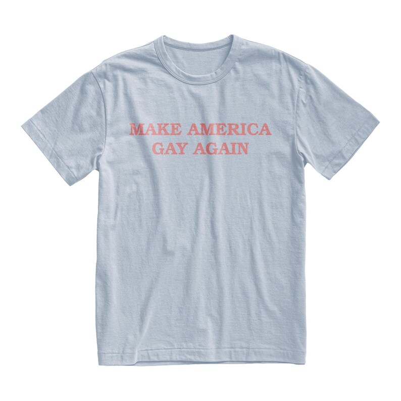 Peut inclure: T-shirt bleu clair avec le texte "Make America Gay Again" imprim&eacute; en rose.